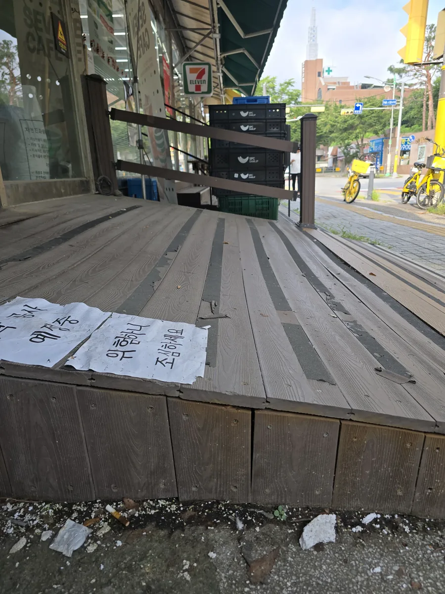 난간이 있는 노후 상가 입구 목재 데크의 판재 상태