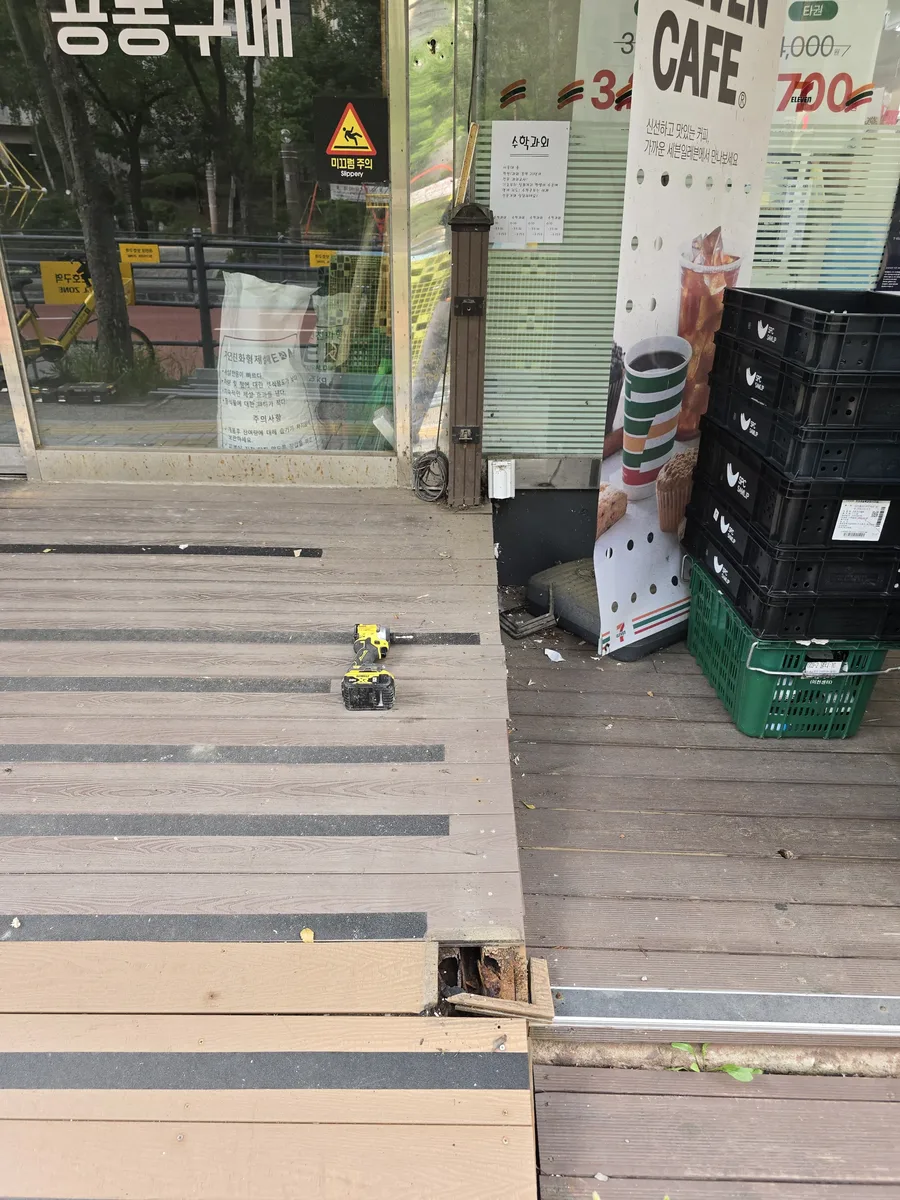 상가 입구 데크 판재를 걷어내는 철거 작업 현장