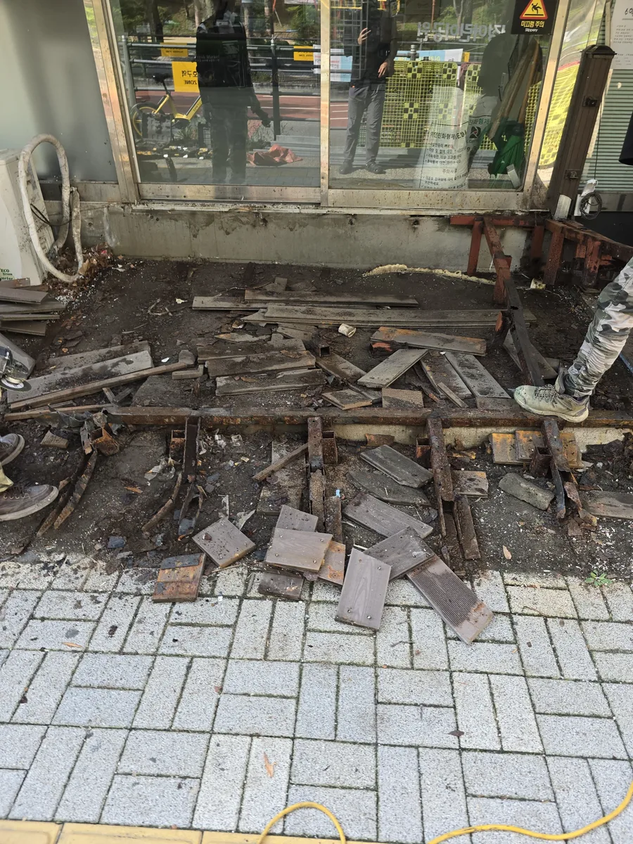 판재를 철거하자 드러난 노후 프레임과 잔재가 있는 상가 입구 현장